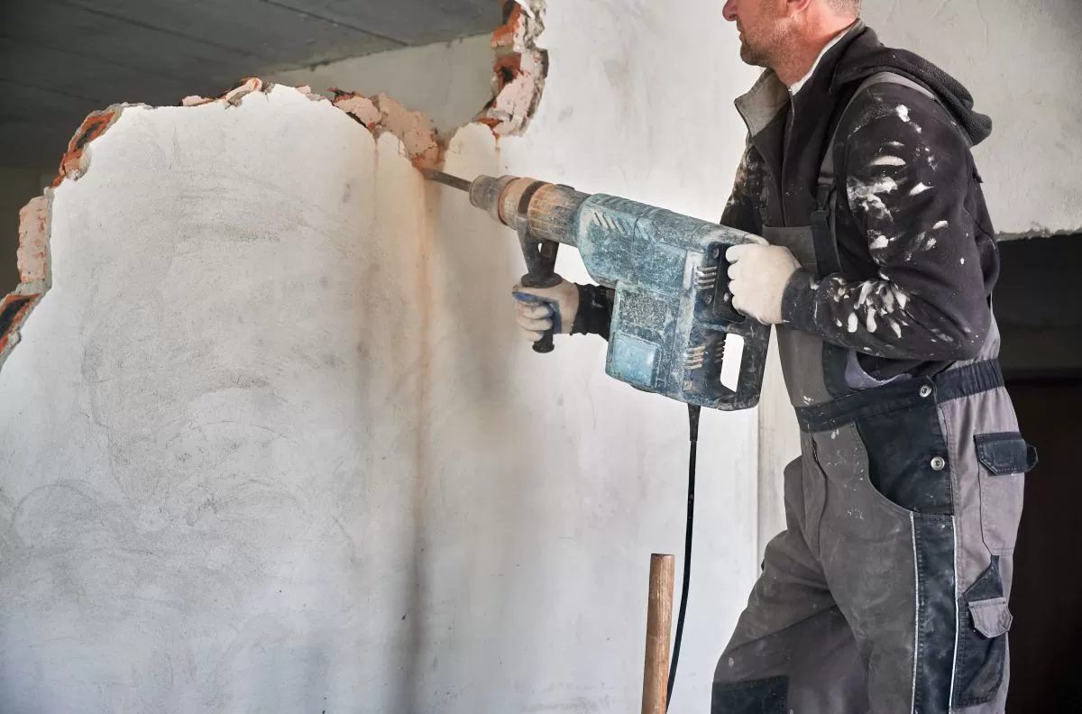 Chipping plaster off a wall with an electric breaker (illustrative image)